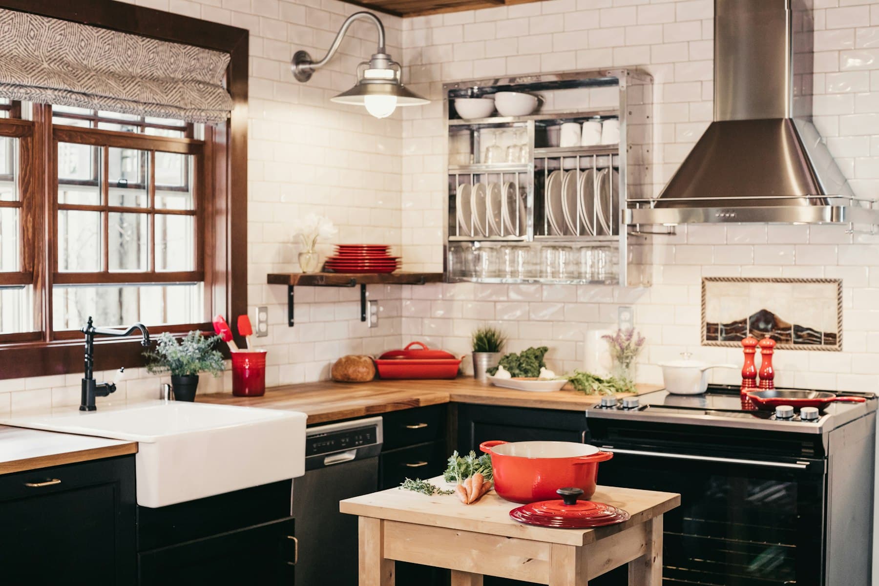 A kitchen with a wooden worktop, white tiles and a farmhouse sink. Editorial photograph, not a product for sale.